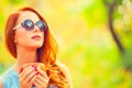 Redhead girl winh cup in the autumn park. Royalty Free Stock Photo