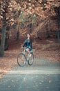 Redhead lady cycling in park. Royalty Free Stock Photo