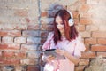 Happy Redhead Lady Enjoying Music on Digital Tablet with Headset against Brick Wall Royalty Free Stock Photo