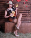 Redhead legged photomodel in minidress and  stockings with guitar  posing in studio Royalty Free Stock Photo