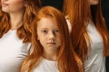Redhead little girl with people with the same hair colour in the background Royalty Free Stock Photo