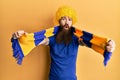 Redhead man with long beard football hooligan cheering game wearing funny wig afraid and shocked with surprise and amazed Royalty Free Stock Photo