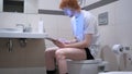 Redhead Man Using Tablet in Bathroom, Commode Royalty Free Stock Photo