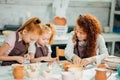 Redhead Mother and kid daughter at home molded from clay and play together Royalty Free Stock Photo