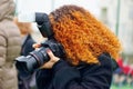 Redhead photographer woman with professional camera Royalty Free Stock Photo