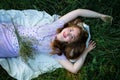 Redhead portrait of a beautiful young sexy red-haired woman, lying in the spring sun, relaxing on the green grass. Royalty Free Stock Photo