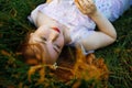 Redhead portrait of a beautiful young sexy red-haired woman, lying in the spring sun, relaxing on the green grass. Royalty Free Stock Photo