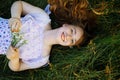 Redhead portrait of a beautiful young sexy red-haired woman, lying in the spring sun, relaxing on the green grass. Royalty Free Stock Photo