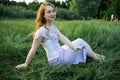 Redhead portrait of a beautiful young sexy red-haired woman, lying in the spring sun, relaxing on the green grass. Royalty Free Stock Photo