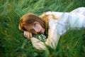 Redhead portrait of a beautiful young sexy red-haired woman, lying in the spring sun, relaxing on the green grass. Royalty Free Stock Photo