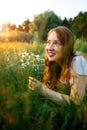 Redhead portrait of a beautiful young sexy red-haired woman, lying in the spring sun, relaxing on the green grass. Royalty Free Stock Photo