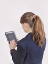 Redhead schoolgirl is holding digital tablet with empty blank screen. isolated over a grey background. Royalty Free Stock Photo