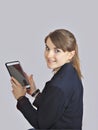 Redhead schoolgirl is holding digital tablet with empty blank screen. isolated over a grey background Royalty Free Stock Photo