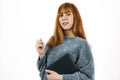 Redhead smiling woman holding a black notebook and showing something with a pen Royalty Free Stock Photo