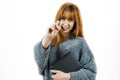 Redhead smiling woman holding a black notebook and showing something with a pen Royalty Free Stock Photo