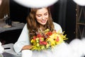 Redhead woman with bouquet of autumn flowers in cafe Royalty Free Stock Photo