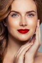 Redhead woman face closeup portrait. Ginger hair, freckles, red lips makeup and red nails