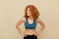 Redhead Woman. Fit Girl Portrait. Smiling Beautiful Female In Sportswear Keeping Hands On Hips. Royalty Free Stock Photo