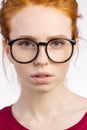 Redhead woman in glasses with hair knot looking at camera on white background Royalty Free Stock Photo