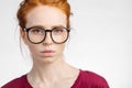 Redhead woman in glasses with hair knot looking at camera on white background Royalty Free Stock Photo