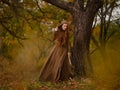 Redhead woman in dress walking in fantasy fairy tale forest