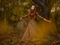 Redhead woman in dress walking in fantasy fairy tale forest