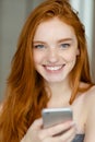 Redhead woman holding smartphone Royalty Free Stock Photo