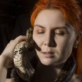 Redhead woman holding snake. close-up photo girl with pygmy python on a white background Royalty Free Stock Photo