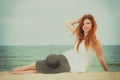 Redhead woman holding sun hat lying on beach Royalty Free Stock Photo