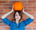 Redhead woman in jeans clothes holding orange autumn pumpkin Royalty Free Stock Photo