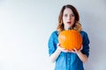 Redhead woman in jeans clothes holding orange autumn pumpkin Royalty Free Stock Photo