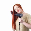 Redhead woman with long hair holding hair dryer and comb Royalty Free Stock Photo