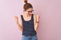 Redhead woman with pigtail wearing striped t-shirt standing over isolated pink background very happy and excited doing winner Royalty Free Stock Photo