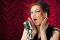 Redhead woman singing into vintage microphone