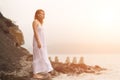 Redhead woman standing on the coast on beach. Royalty Free Stock Photo