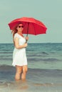 Redhead woman walking on beach holding umbrella Royalty Free Stock Photo