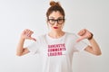 Redhead woman wearing funny t-shirt with irony comments over isolated white background with angry face, negative sign showing