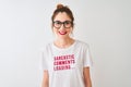 Redhead woman wearing funny t-shirt with irony comments over isolated white background with a happy face standing and smiling with