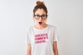 Redhead woman wearing funny t-shirt with irony comments over white background scared in shock with a surprise face,