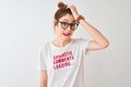 Redhead woman wearing funny t-shirt with irony comments over white background stressed with hand on head, shocked with