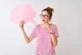 Redhead woman wearing glasses holding cloud speech bubble over isolated white background serious face thinking about question,