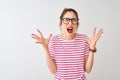 Redhead woman wearing glasses striped t-shirt and pigtail over isolated white background crazy and mad shouting and yelling with Royalty Free Stock Photo