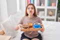 Redhead woman wearing pajama holding breakfast tray puffing cheeks with funny face Royalty Free Stock Photo