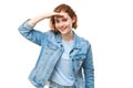 Redhead young woman in denim jacket looks future, looking far away distance with hand over head isolated on white background Royalty Free Stock Photo