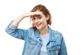 Redhead young woman in denim jacket looks future, looking far away distance with hand over head isolated on white background Royalty Free Stock Photo