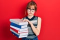 Redhead young woman holding a pile of books depressed and worry for distress, crying angry and afraid Royalty Free Stock Photo
