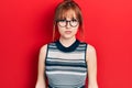 Redhead young woman wearing casual clothes and glasses with serious expression on face Royalty Free Stock Photo
