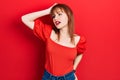 Redhead young woman wearing casual red t shirt smiling confident touching hair with hand up gesture, posing attractive and Royalty Free Stock Photo