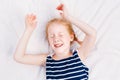 Redheaded Caucasian child girl in striped nautical sleeveless shirt sleeping Royalty Free Stock Photo