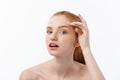 Redheaded woman shows fingers on acne on her face. Royalty Free Stock Photo